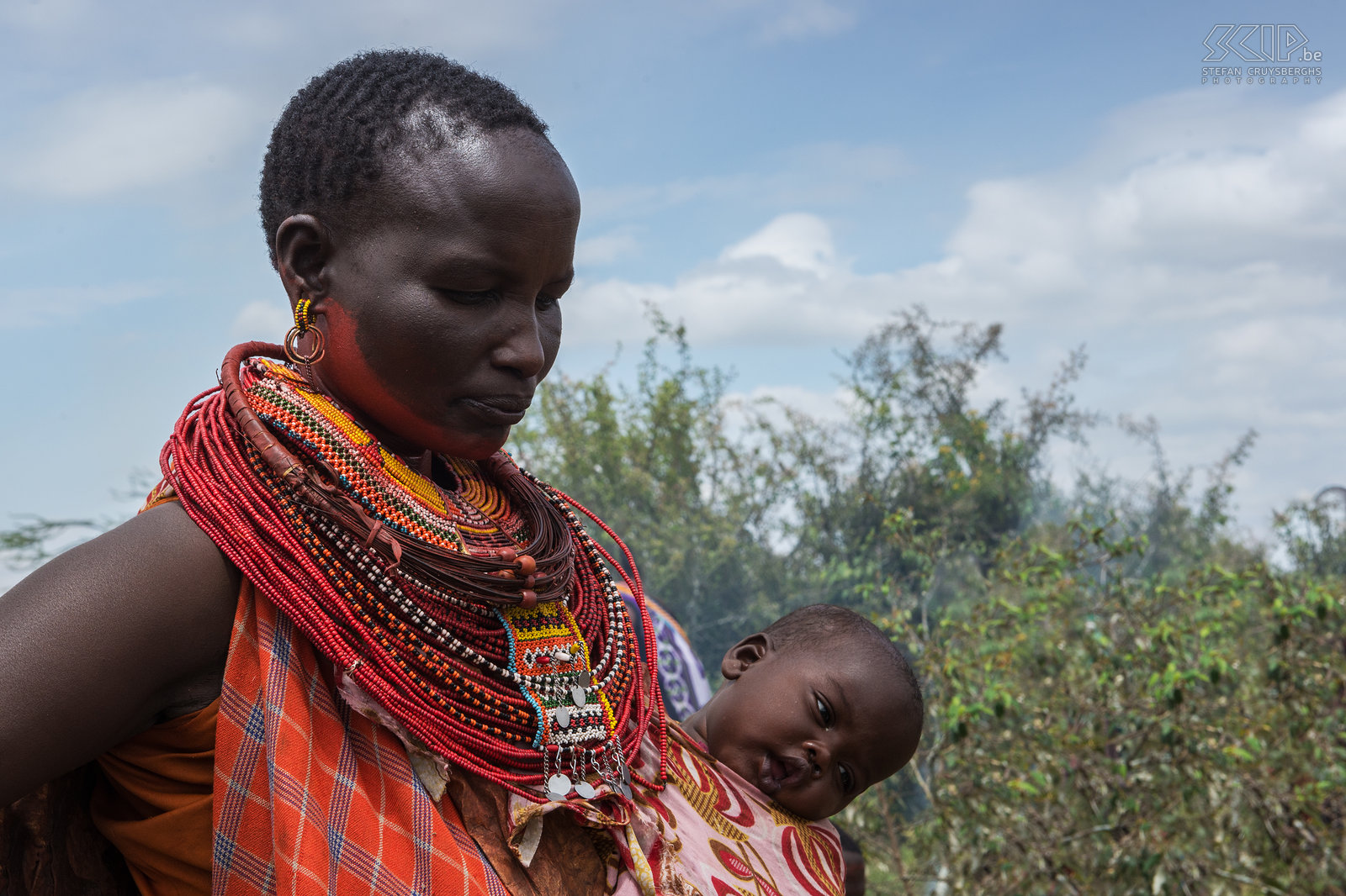 Kisima - Samburu lmuget - Vrouw met baby Moeders dragen hun baby in een kleurrijke katoenen doek die rond hun middel word gebonden ofwel op hun rug word gedragen. Stefan Cruysberghs